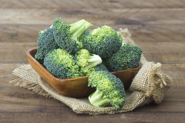 Raw broccoli in a bowl on wooden background - Photo, Image