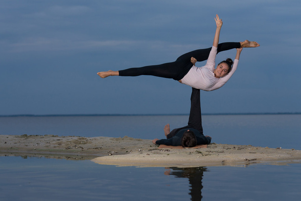 Perfect acroyoga. Beautiful young couple is balancing doing acro - Photo, Image