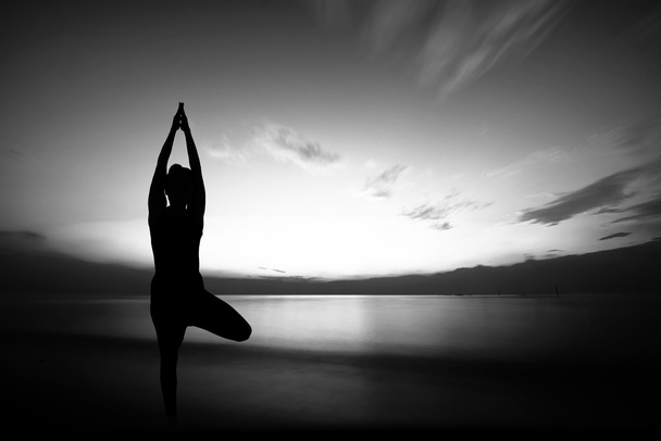 femme faisant du yoga au coucher du soleil - Photo, image