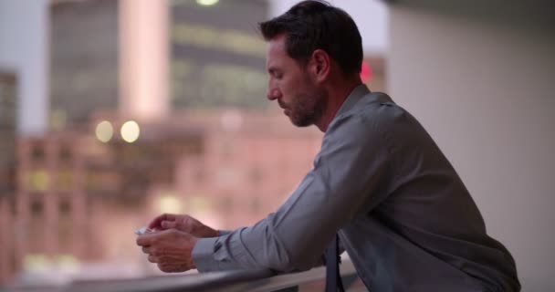 Businessman hodling smartphone on office balcony - Séquence, vidéo