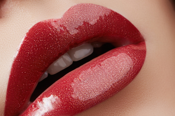 Close-up of female lips with bright makeup. Macro of woman's face. Fashion lip make-up with red gloss.Red lipgloss makeup on full female lips - Фото, зображення
