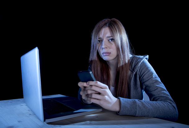 worried teenager using mobile phone and computer as internet cyber bullying stalked victim abused - Photo, Image