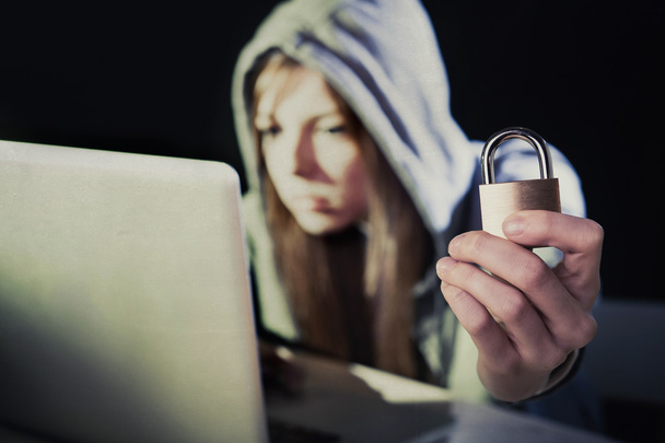 jong aantrekkelijk tiener vrouw dragen hoodie hacken laptop cyberc - Foto, afbeelding