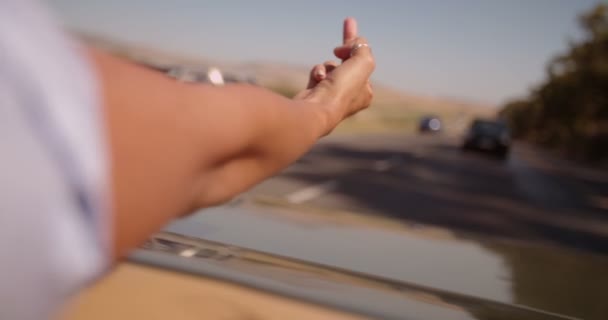 コンバーチブル車の後部座席から指を弾く少女 - 映像、動画