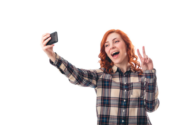 Portrait of a young woman making selfie photo on smartphone - Photo, Image