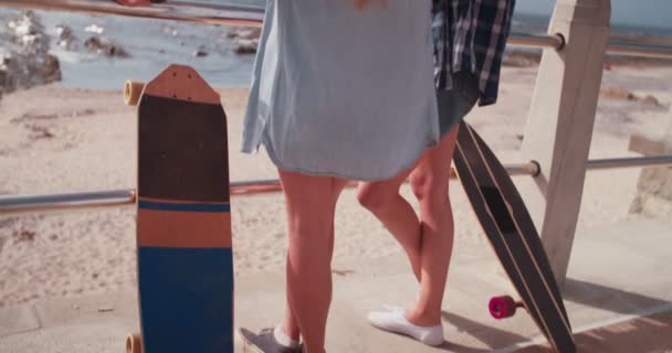 Девушки-скейтеры стоят на берегу моря со скейтбордами
 - Кадры, видео