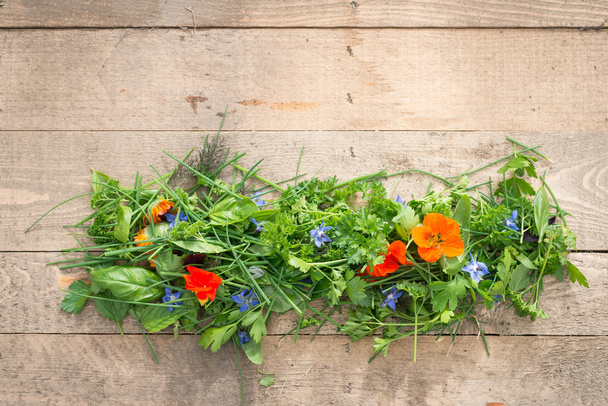 Haufen essbarer Blumen und Kräuter auf Holzplanken - Foto, Bild