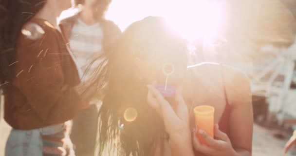 Tyttö juhlii kuplia ulkona auringonlaskun aikaan
 - Materiaali, video