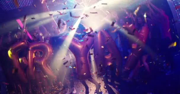 φίλοι χορό σε ένα νυχτερινό κέντρο διασκέδασης κρατώντας Friyay μπαλόνια - Πλάνα, βίντεο