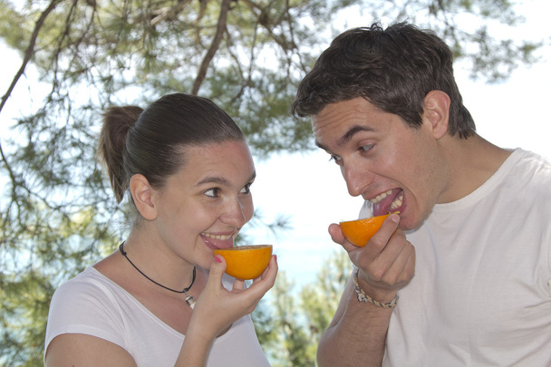 mladý pár lízání čerstvý pomeranč - Fotografie, Obrázek