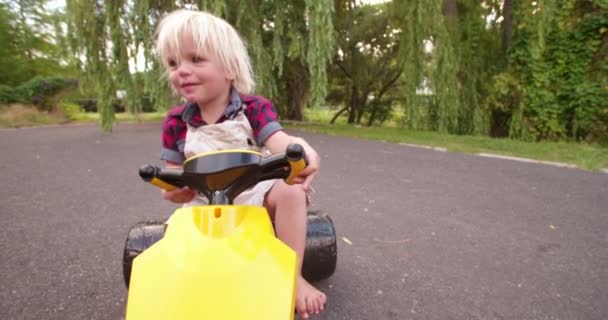niño jugando con su coche de juguete en la carretera
 - Metraje, vídeo