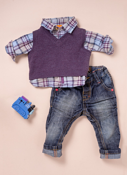 Camisa tamanho infantil, camisola e jeans com brinquedo
 - Foto, Imagem