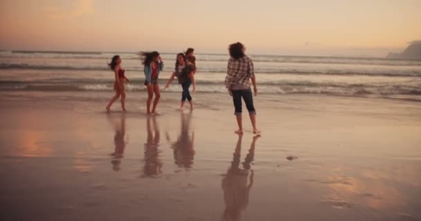 Freunde machen Huckepackfahrten am Strand - Filmmaterial, Video