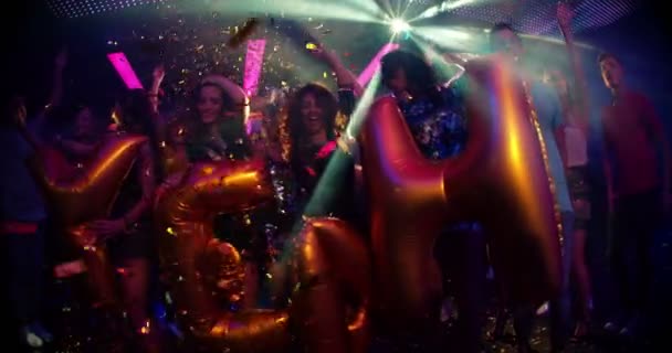 przyjaciele w klub nocny z tak balony i konfetti - Materiał filmowy, wideo
