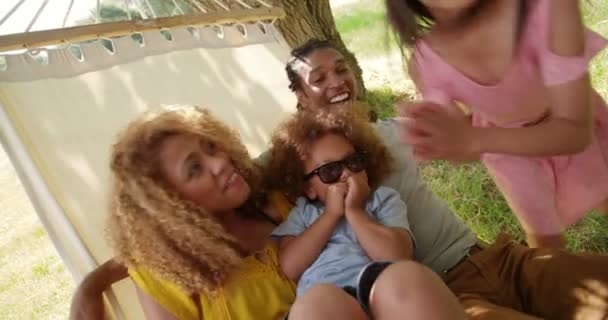 Famille multi-ethnique se détendre ensemble sur un hamac
 - Séquence, vidéo