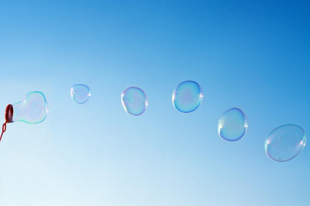 Soap bubbles over clear blue sky - 写真・画像