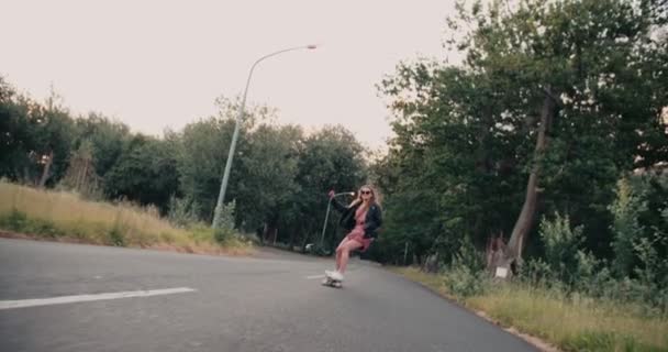 Skater Dziewczyna jazda wzdłuż drogi z drzew - Materiał filmowy, wideo
