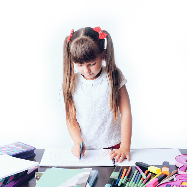 little girl draws a teenage student decides to write homework wi - Fotografie, Obrázek