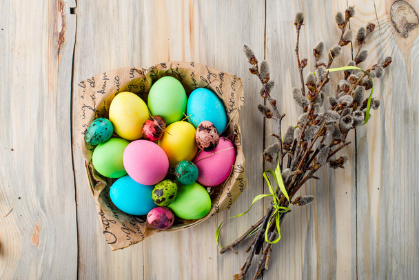 Colorful Easter eggs in the basket with willow branches - Photo, image