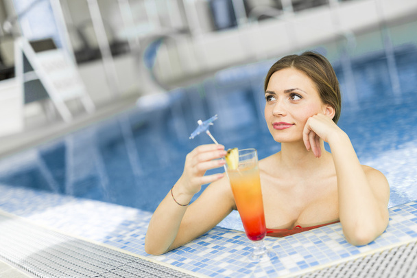 Woman in a pool with a cocktail - Foto, imagen