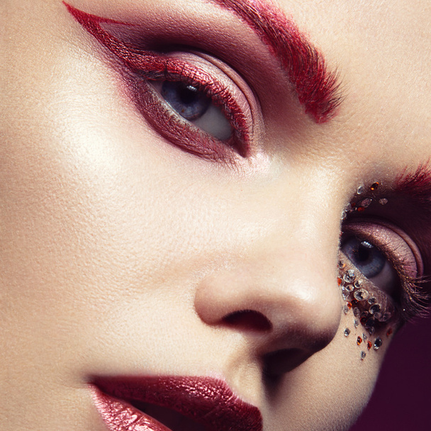 Beautiful girl with a bright red fashion makeup and crystals on  - Fotoğraf, Görsel