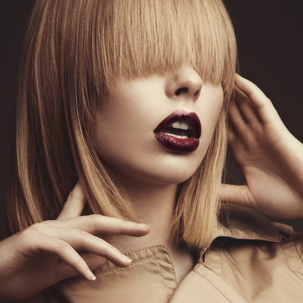 Beautiful blonde woman in a bright coat and dark lips, showing d - Foto, Imagem