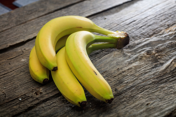 Bananas amarelas frescas, na superfície de madeira
 - Foto, Imagem