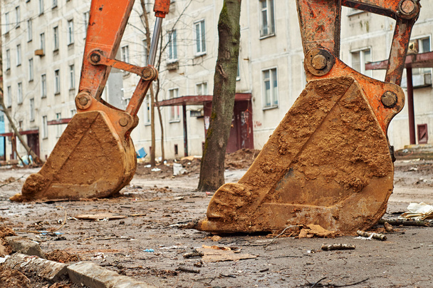 Massive buckets of the excavators standing on the dirty asphalt  - Photo, Image