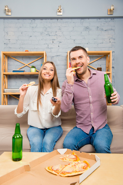 Excited young couple watching film with beer and pizza - Foto, immagini