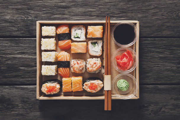 Set sushi maki en rollen in zwart rustiek hout. - Foto, afbeelding
