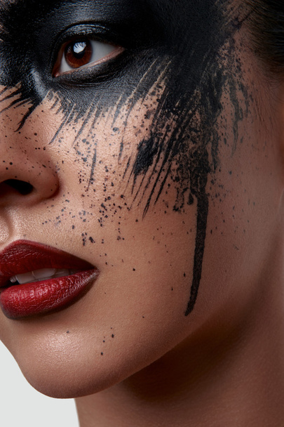 Closeup Portrait of Model with black Paint on her Face - Foto, imagen