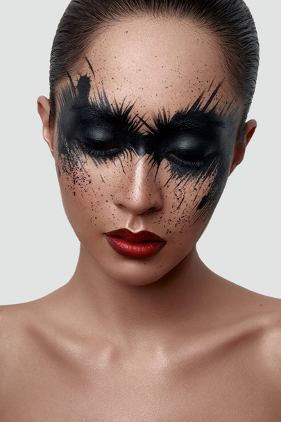 Fashion Girl with black Paint Splashes on her Face - Foto, afbeelding