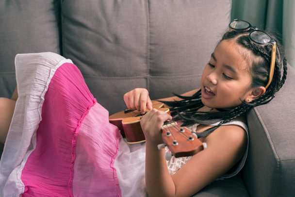 Szczęśliwy uśmiechający się dziewczyna nauczyć grać na Ukulele - Zdjęcie, obraz