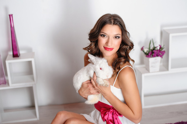Beautiful young woman with a pet rabbit in studio - Photo, Image