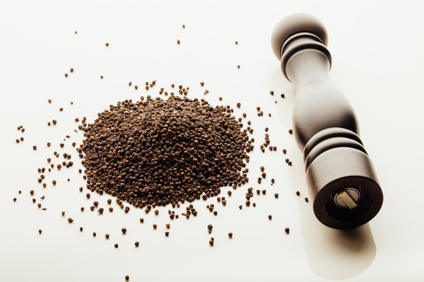 pepper mill and peppercorns heap, white background - Photo, image
