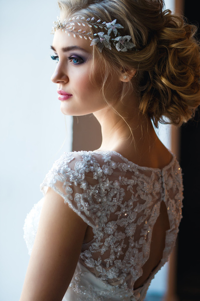 Beautiful blonde bride in gorgeous luxury dress in a loft space in a morning. Modern wedding photo - Fotografie, Obrázek