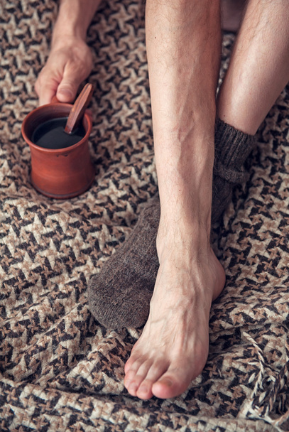 Adam ayakta bir kahve ve yünlü ekose - Fotoğraf, Görsel