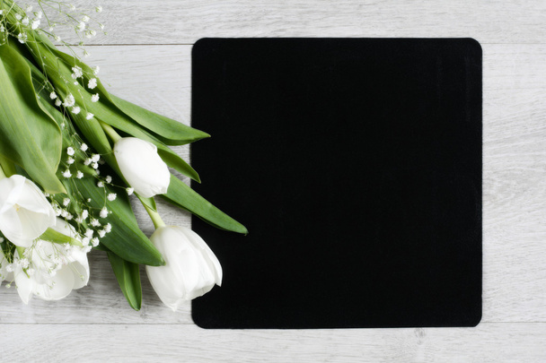 Flowers background. White tulips and chalkboard with copy space, top view - Photo, image