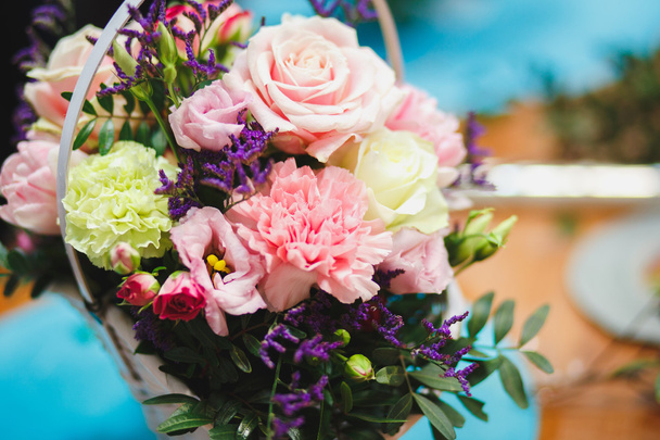 Florist workplace: pretty bouquet in a basket on a background of flowers and accessories. soft focus - Fotó, kép