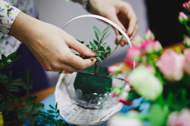 Floral workshop - florist makes a bouquet in a basket. Students florists work together. - Фото, изображение