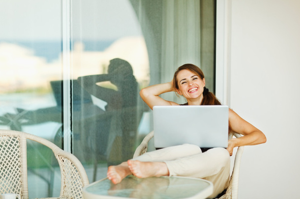Happy woman enjoying free time with laptop on terrace - Foto, immagini