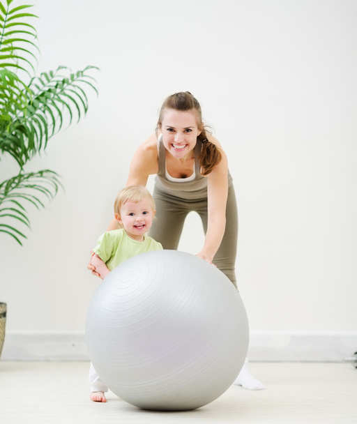 Portrait de mère et bébé jouant avec le ballon de fitness
 - Photo, image