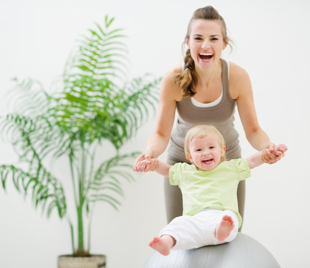 Mother and baby playing with fitness ball - Foto, imagen