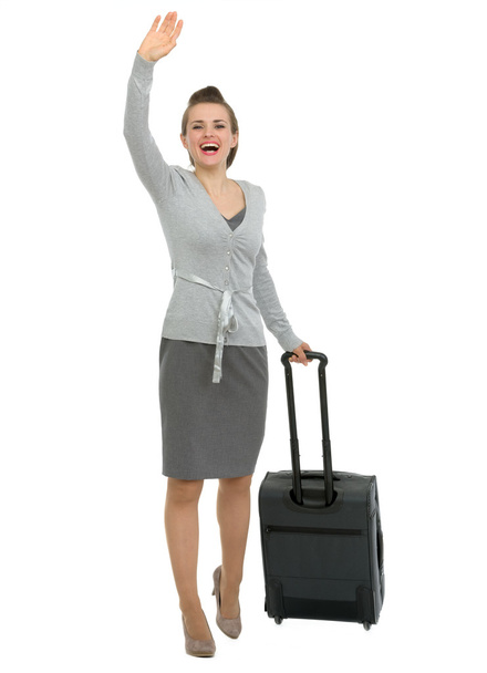 Excited traveling woman with suitcase waving hand - Photo, image