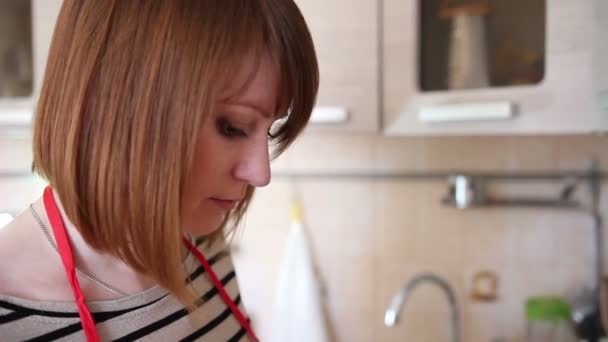 mladá žena je na vaření v kuchyni - Záběry, video