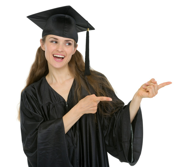 Happy graduation student girl pointing sideways - Φωτογραφία, εικόνα