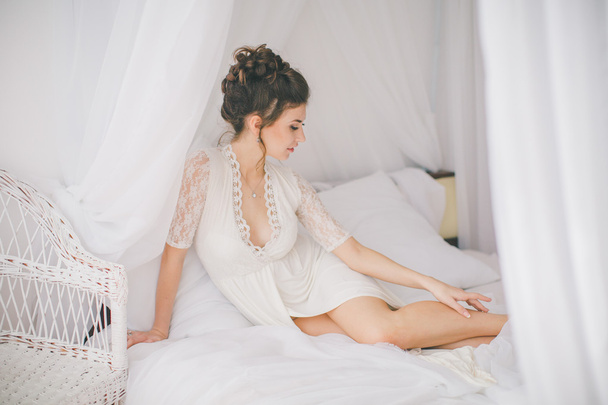 Beautiful brunette girl in white bedroom  - Fotografie, Obrázek