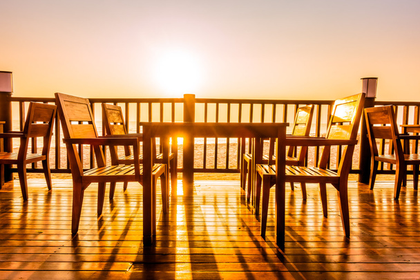 Cadeiras vazias ao ar livre e mesa na praia
 - Foto, Imagem