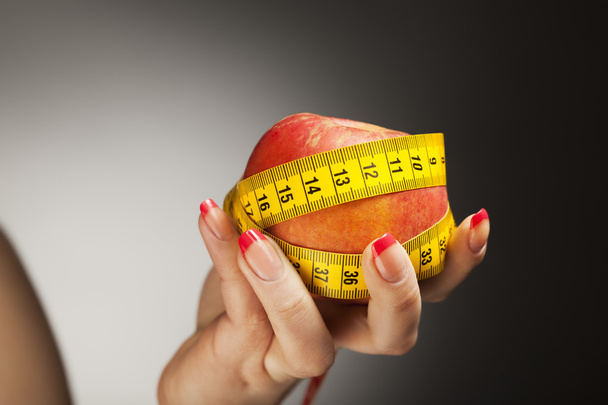 diet apple with measure tape in woman hand - Фото, изображение
