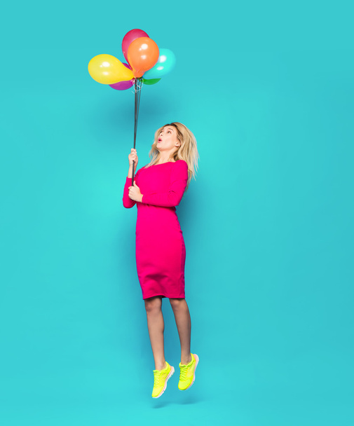 blonde woman with balloons on blue - Foto, afbeelding